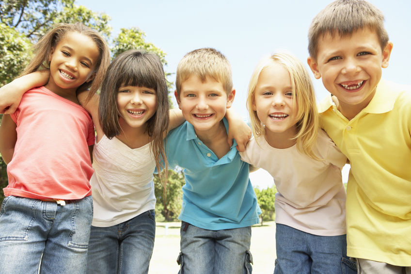 Group Of Smiling Children Relaxing In Park Healthy Choices