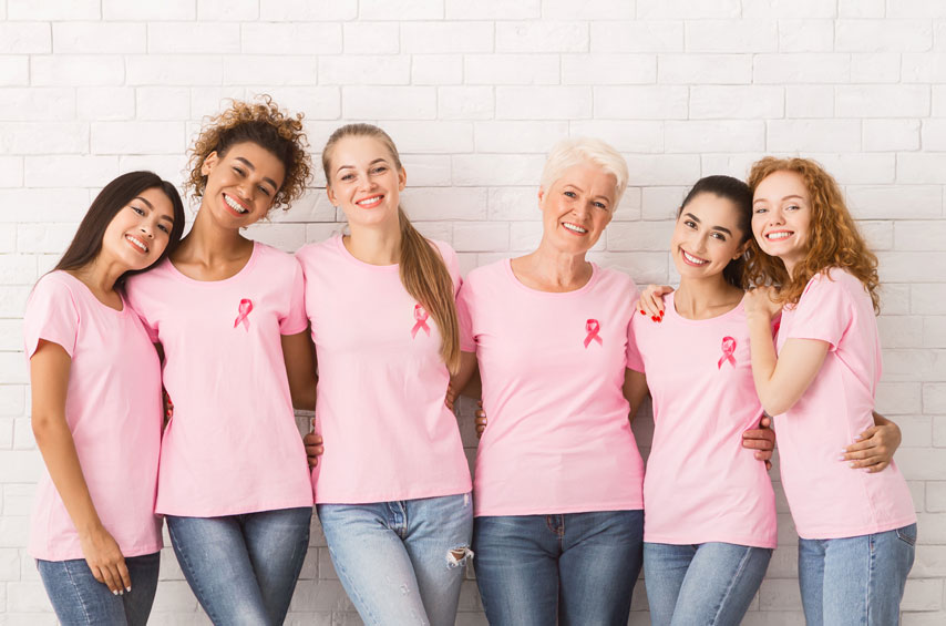 happy multiracial ladies breast cancer tshirts embracing standing indoor
